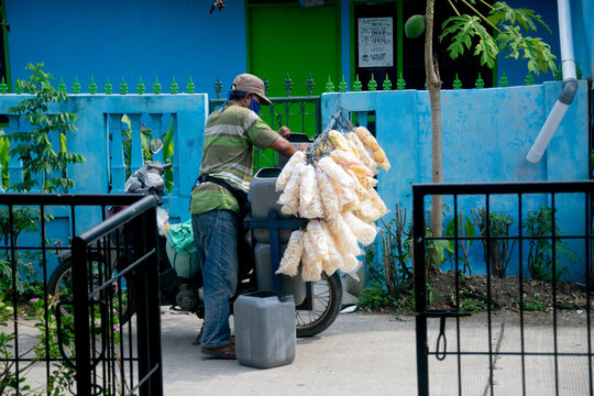 bekasi,indonesia - february 10 2026 ;Street Vendor Preparing Traditional Snacks on a Bicycle Cart Outside a Colorful Neighborhood Building