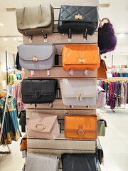 Leather and fabric bags of different colors exhibited in the modern shopping mall or market