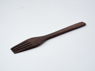 The fork is made of wood, with a white background, seen from above.