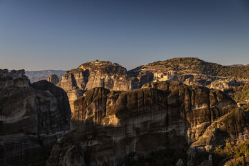 Sunset over Meteora. Amazing wide angle photo with the landscape of Meteora, iconic place with Greek orthodox monasteries in the mountains, during sunset. Travel to Greece.