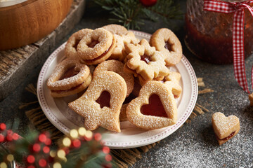 A plate of traditonal Linzer Christmas cookies filled with marmalade and dusted with sugar