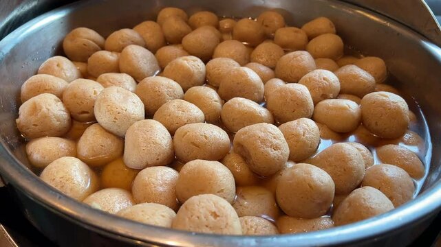 Pieces of round gurer roshogolla or rasgulla at a Bengali sweet shop.