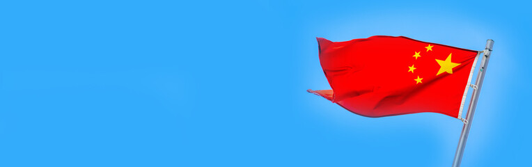 The Chinese flag fluttering on a metal flagpole
