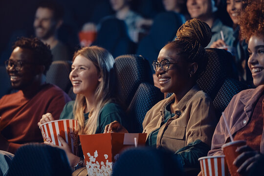 Multiracial group of happy friends at movie theatre. - Powered by Adobe