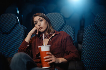 Bored woman watching movie at cinema.