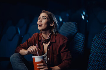 Young woman watching movie at cinema.