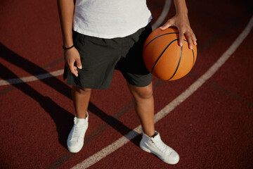 Naklejka premium Basketball ball in hand of young girl player