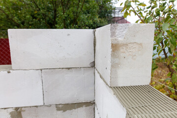 A white brick wall with a white brick on the corner