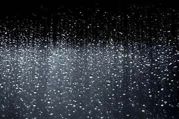 Obraz premium Rain Falls Gently on a Dark Night Background with Water Droplets Sparkling