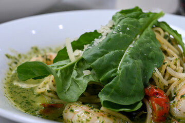 Spaghetti with seafood such as shrimp and vegetables such as basil