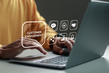 Customer engagement concept. Person using laptop with customer engagement icon on virtual screen....