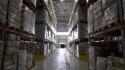 Huge factory warehouse with large boxes of finished products. Hall contains high shelves for storing materials in order to save work space