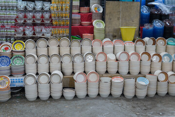 Ceramic pottery vessels stacked on the ground at a flea market in Mexico.
