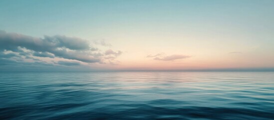 Fototapeta premium Serene ocean sunset with calm waves and pastel sky.