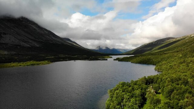 Aerial Drone Flight Over a Vast Norwegian Lake with a Cozy House Nestled Among the Trees on the Shore