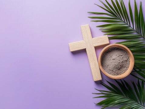 Wooden cross, palm leaf and a bowl of ash on purple background for Ash Wednesday Palm Sunday Catholic symbolism. Copy space
