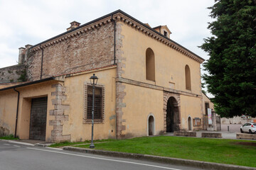 Obraz premium A view of a historic stone and brick building with arched openings, likely part of the fortifications or within the old town of Peschiera del Garda