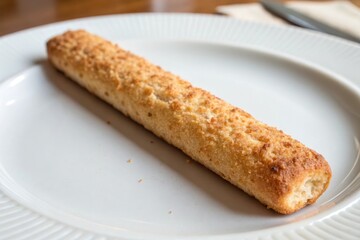 A crispy breadstick with visible texture on a plain white plate emphasizing its crunchiness and freshness, food, crispy breadstick, crunchy texture, fresh, white background