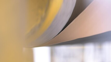 Conveyor drying cylinder rotates paper to remove moisture in workshop. Process adds stability to web for further processing by heat operation