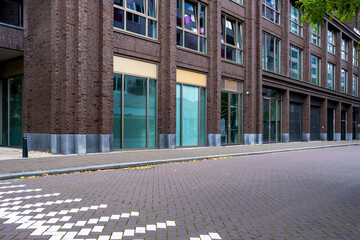 The architectural design showcases a modern brick facade with large glass windows that contribute to the building's aesthetic appeal and transparency, ideal for businesses.