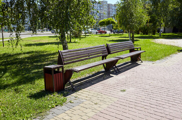 Rest area with benches surrounded by trees and ornamental shrubs in Kyiv, Europe. Place to rest in the city park at summer