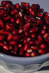 pomegranate seeds in a purple bowl