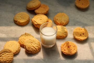 Milk in glass and cookies on the table, closeup of photo