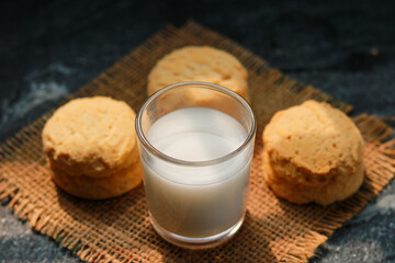 Milk in glass and cookies on the table, closeup of photo