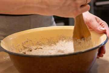 Woman kneads the dough in the bowl. Baking