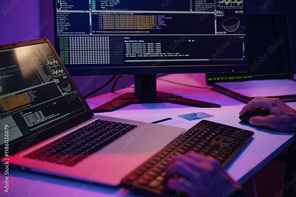 Poster close-up of it worker writing security codes on computer at his workplace in dark office