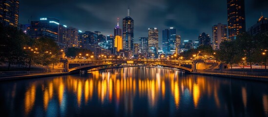Fototapeta premium Night cityscape with bridge and city lights reflected in water.
