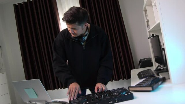 Asian DJ is spinning with a CDJ to play music and select songs to match the rhythm of the songs in the home studio.