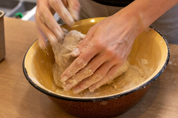 Woman kneads the dough in the bowl. Baking