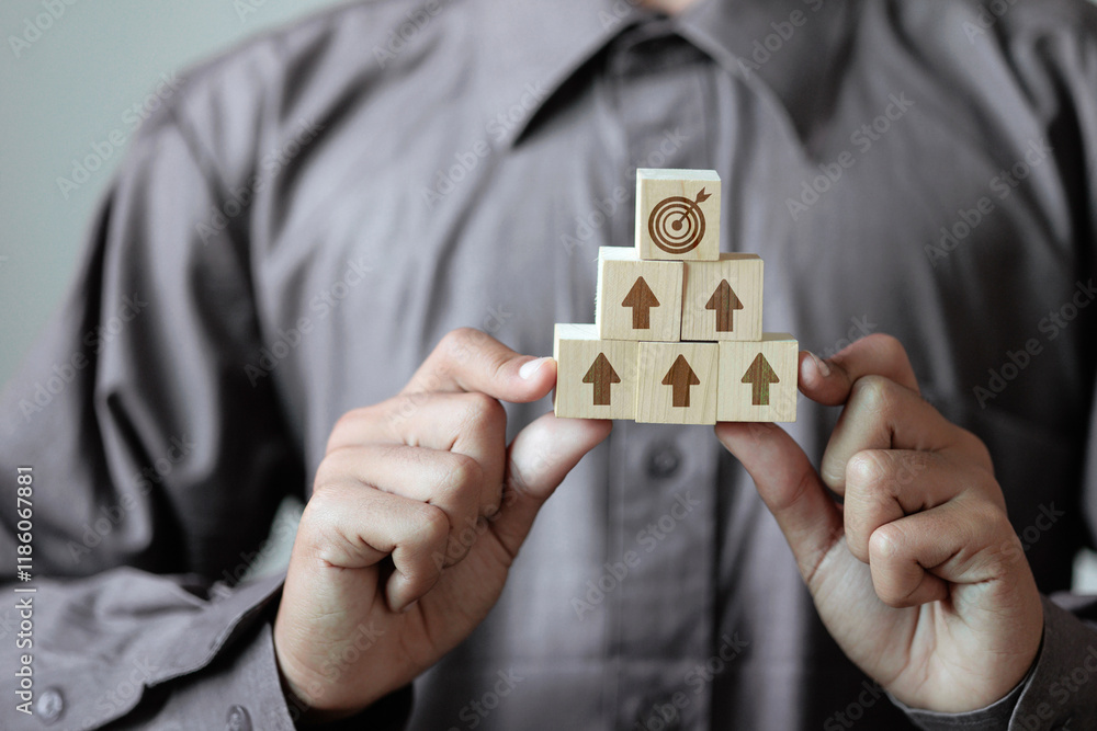 Poster a man holds a block with an arrow pointing up, with a target symbol on top.