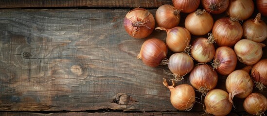 Obraz premium Fresh onion bulbs on a rustic wooden table with copyspace Top view