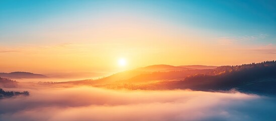 Fototapeta premium Sunrise and clear blue sky above a foggy landscape. with copy space image. Place for adding text or design
