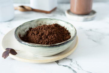 A ceramic bowl containing a cocoa powder, with its soft, velvety texture.