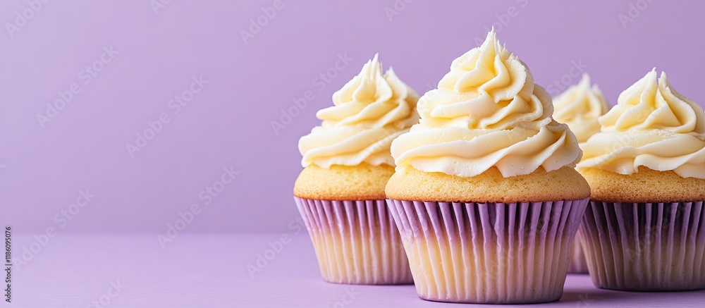 Aufkleber cupcakes adorned with yellow cream on a violet pastel background with copy space perfect for a birth