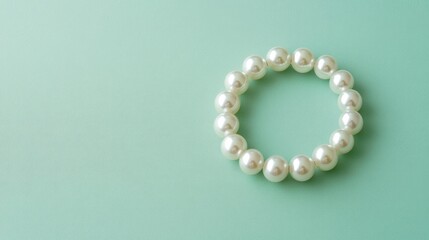 Delicate pearl bracelet showcased on a soft pastel green background, elegant and minimal.