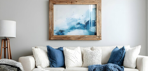 Living room with blue-and-white artwork, wood-framed mirror, and a comfortable sofa for relaxation.