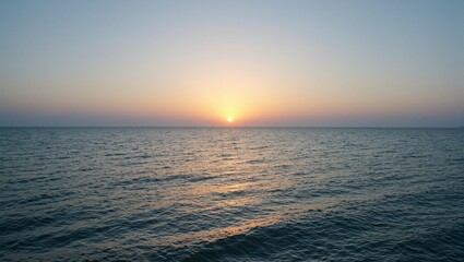 Obraz premium Tranquil dawn over a bay golden sun calm waters soft hues reflecting in gentle waves