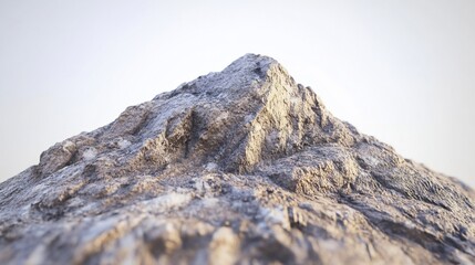 Close-up view of a rugged, light gray rock formation, resembling a mountain peak against a bright, almost white sky.