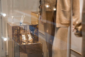 An elegant showcase of an expensive luxury store with stylish mannequins in clothes and evening lighting. The concept of shopping and sales.