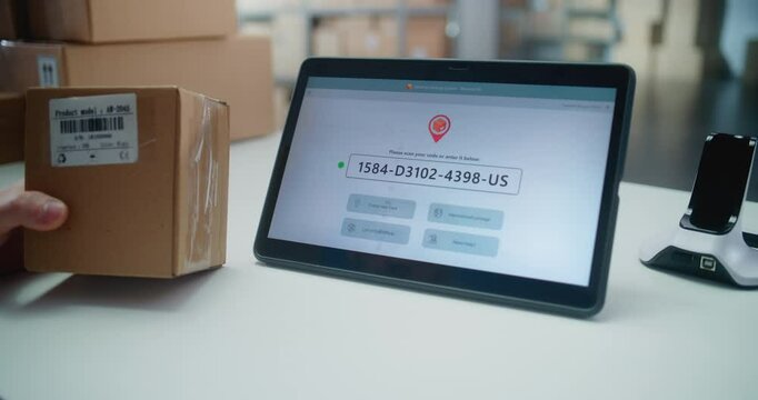 Inventory Manager Scans Code on Cardboard Box with Barcode Scanner, Checks Parcel Information. Tablet Computer Screen Shows Delivery Tracking System for Monitoring Package with Online Orders. Close Up