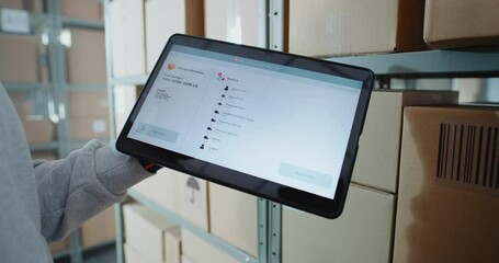 Postal Warehouse Worker Scans QR Code on Cardboard Box with Barcode Scanner, Monitors Package Information. Tablet Computer Screen Shows Delivery Tracking Software to Check Parcel Routing. Close Up. - Powered by Adobe