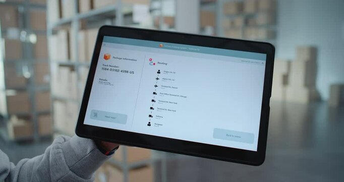 Postal Warehouse Worker Monitors Package Information. Tablet Computer Screen Shows Delivery Tracking App Interface Scanning Code of Parcel with Online Orders to Check Routing to Customer. Close Up.
