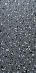 Close-up of a speckled gray terrazzo floor with various stone aggregates.