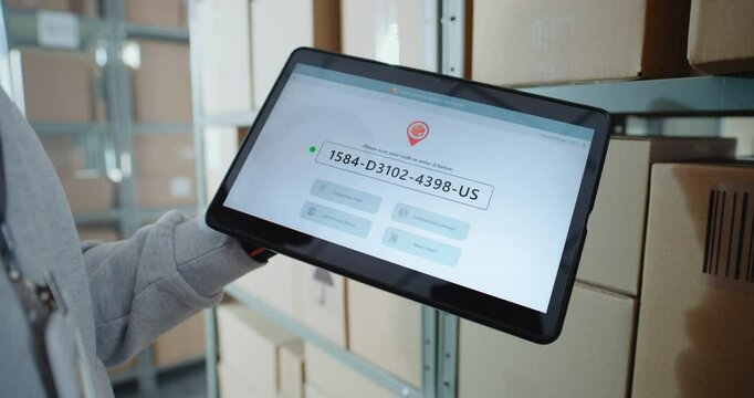 Inventory Manager Scans Code on Cardboard Box with Barcode Scanner, Checks Parcel Information. Tablet Computer Screen Shows Delivery Tracking System for Monitoring Package with Online Orders. Close Up