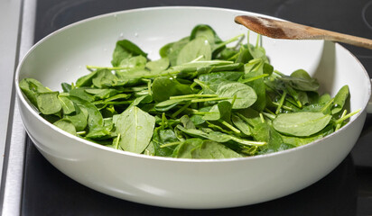 Fresh Spinach in a White Pan Ready to Cook Close-Up