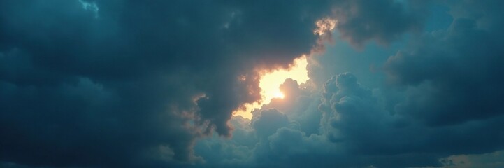 Fototapeta premium A thin sliver of light breaks through thick dark clouds forming a crescent shape on the horizon, stormy weather, cloudy